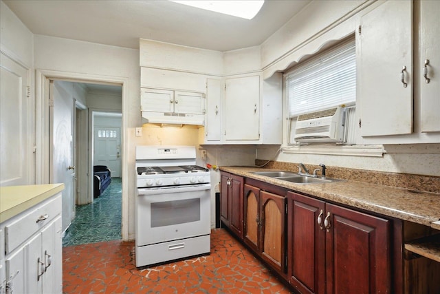 kitchen with white gas range, sink, and white cabinets