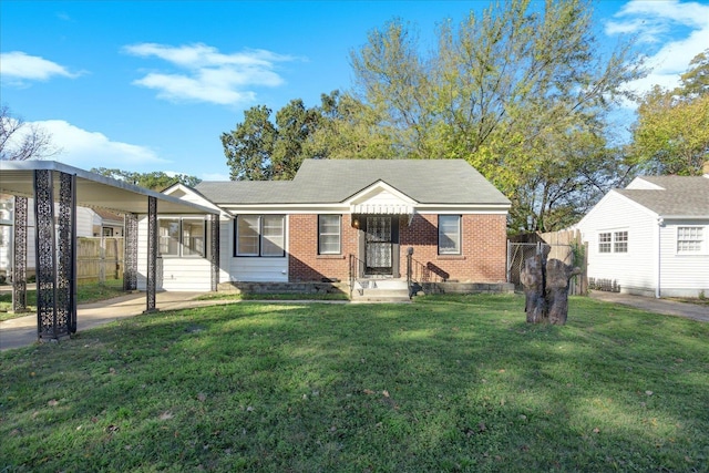 view of front of house featuring a front lawn, fence, and brick siding