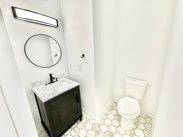 bathroom featuring tile patterned flooring, vanity, and toilet