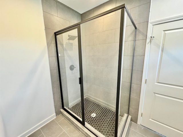 bathroom with tile patterned flooring and a shower with door