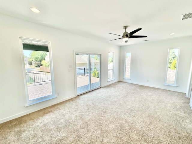 empty room featuring ceiling fan and light carpet