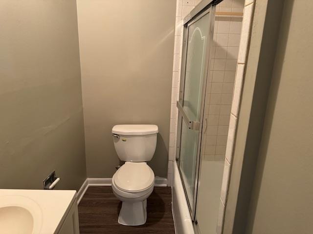 full bathroom with vanity, toilet, hardwood / wood-style floors, and enclosed tub / shower combo