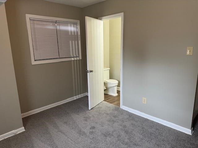 unfurnished bedroom with carpet and connected bathroom