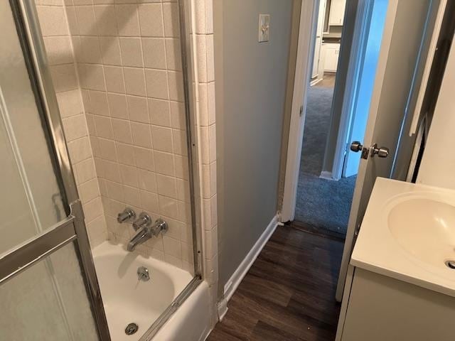 bathroom featuring vanity, hardwood / wood-style flooring, and bath / shower combo with glass door