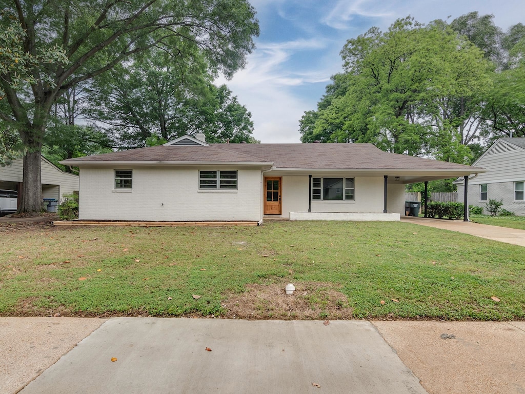 view of front of house with a front yard and a carport