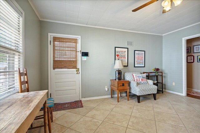 living area featuring light tile patterned floors, ceiling fan, a wealth of natural light, and ornamental molding