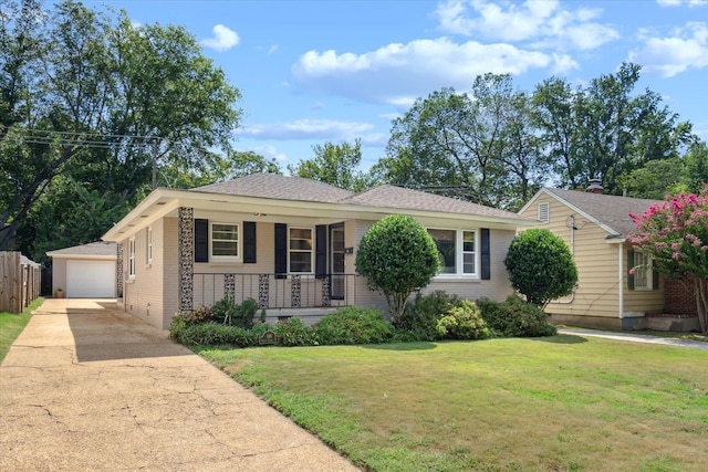 ranch-style home featuring a porch, a garage, a front lawn, and an outdoor structure