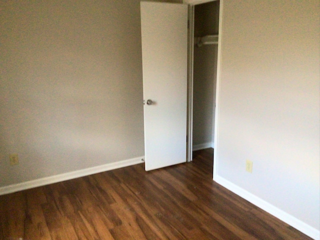 unfurnished bedroom featuring dark wood-type flooring and a closet