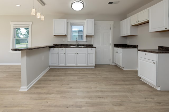 1111 N Watkins St, Memphis, TN 38107 - kitchen featuring a peninsula, healthy amount of natural light, white cabinetry, light wood-style floors, and recessed lighting