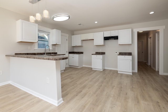 1111 N Watkins St, Memphis, TN 38107 - kitchen with a peninsula, light wood-type flooring, white cabinetry, and recessed lighting