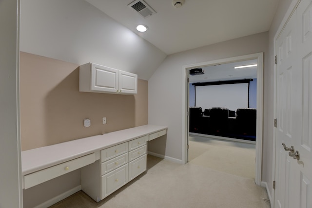 unfurnished office featuring light carpet and lofted ceiling