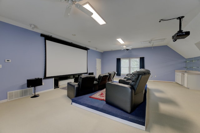 carpeted home theater with vaulted ceiling and ceiling fan