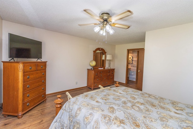 bedroom with a textured ceiling, hardwood / wood-style floors, and ceiling fan