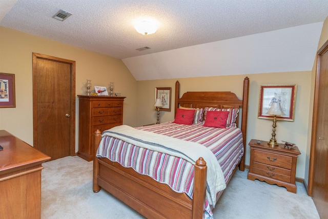 bedroom featuring light carpet, lofted ceiling, and a textured ceiling