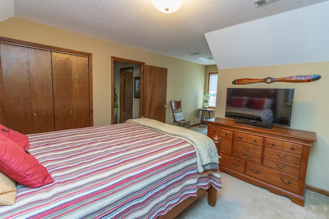 carpeted bedroom with a closet and a textured ceiling