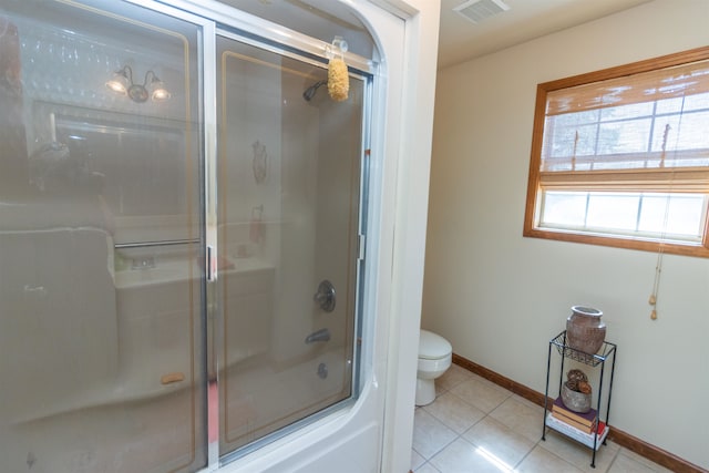 bathroom featuring tile patterned flooring, toilet, and an enclosed shower