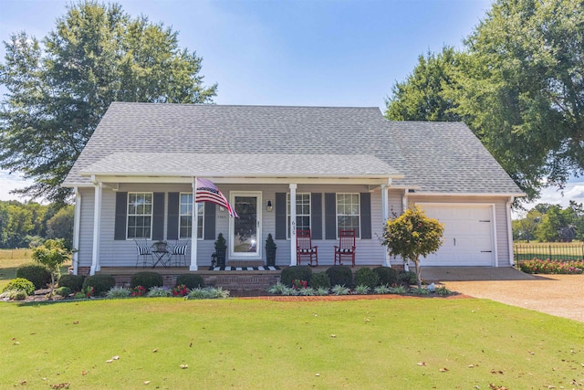 view of front of house with a front yard, covered porch, and a garage