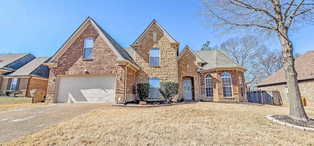 view of front of property featuring stone siding, concrete driveway, brick siding, and a front lawn