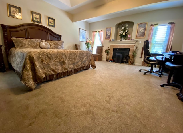 carpeted bedroom with multiple windows and a fireplace