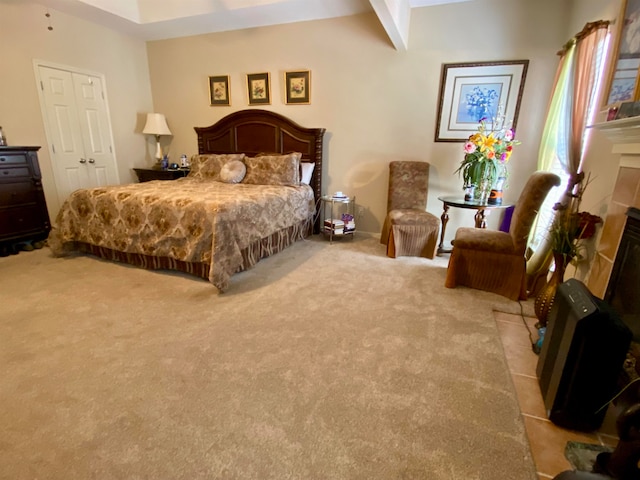 bedroom featuring light colored carpet, a fireplace, and beamed ceiling