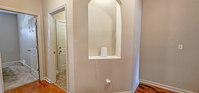 hall featuring baseboards and wood finished floors