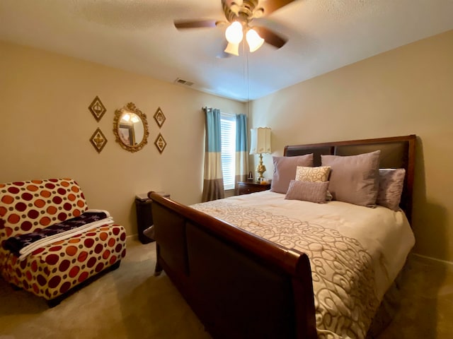 bedroom with a textured ceiling, ceiling fan, and carpet flooring