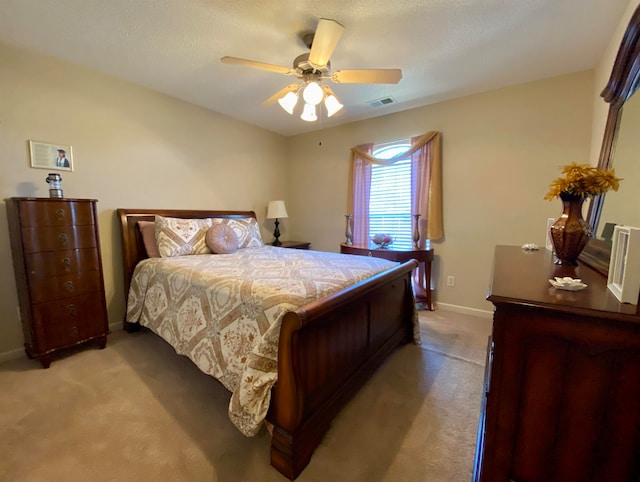 bedroom featuring a textured ceiling, ceiling fan, and carpet floors