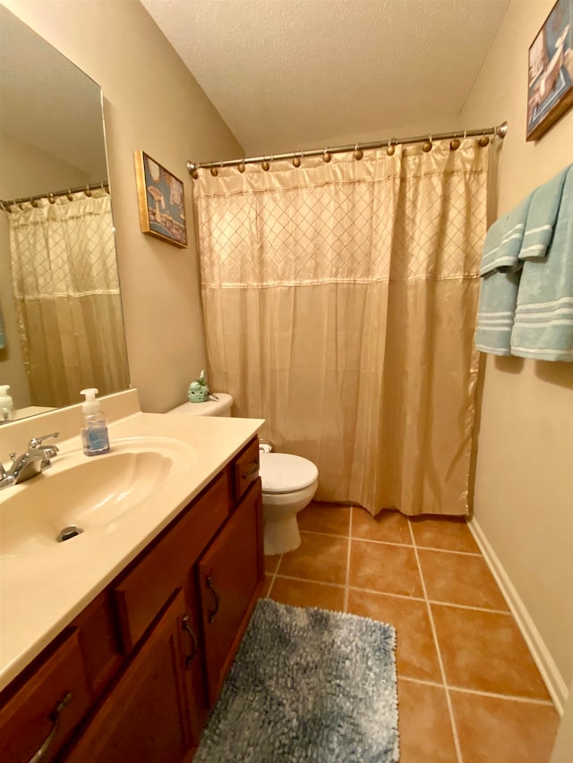 bathroom featuring vanity, toilet, tile patterned flooring, and a textured ceiling