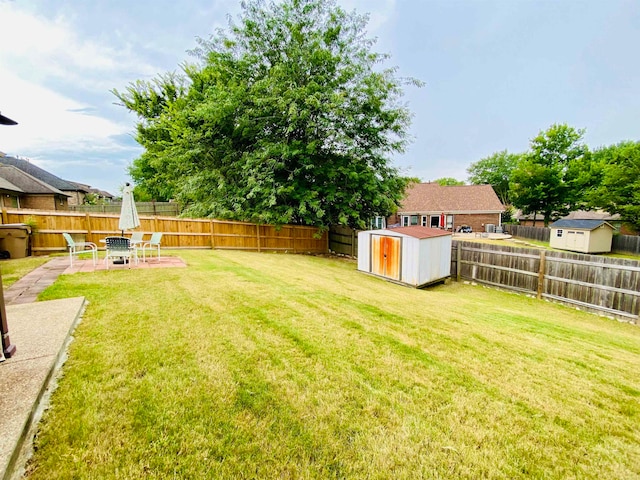 view of yard featuring an outdoor fire pit, a shed, and a patio area