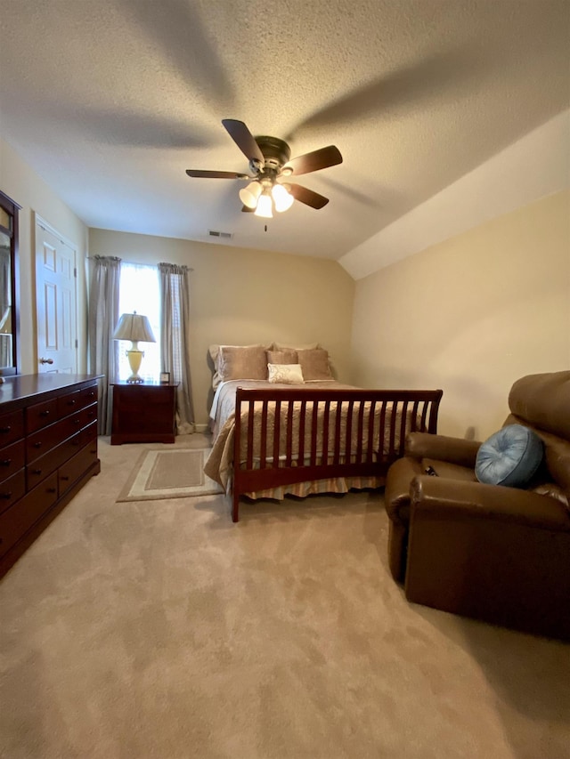 bedroom with a textured ceiling, light colored carpet, a ceiling fan, visible vents, and vaulted ceiling