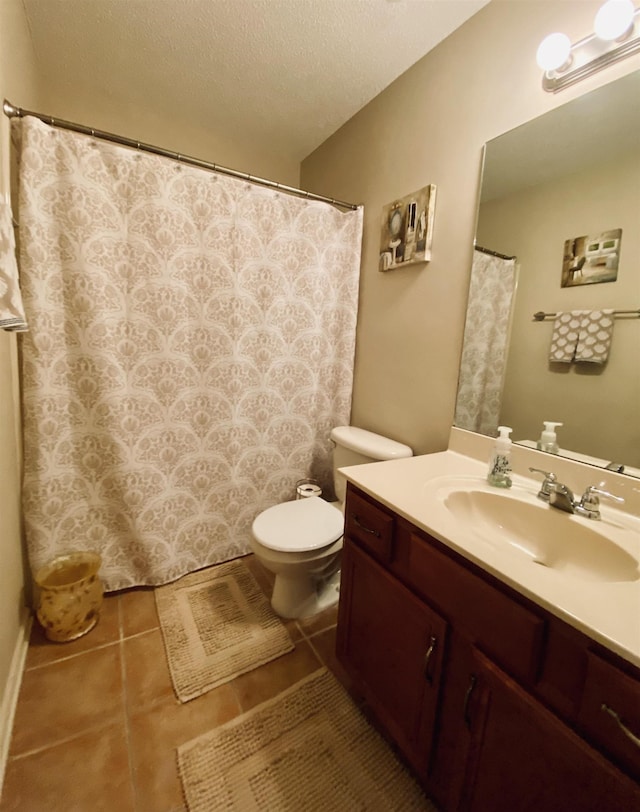 full bathroom featuring toilet, a textured ceiling, tile patterned flooring, and vanity