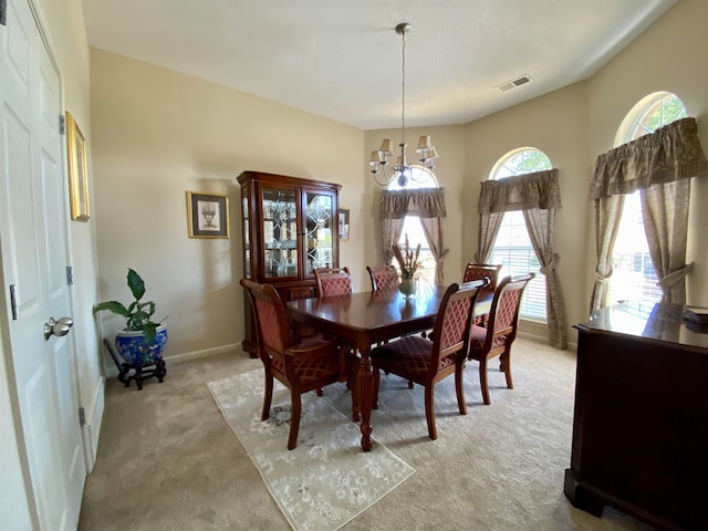 carpeted dining space featuring an inviting chandelier