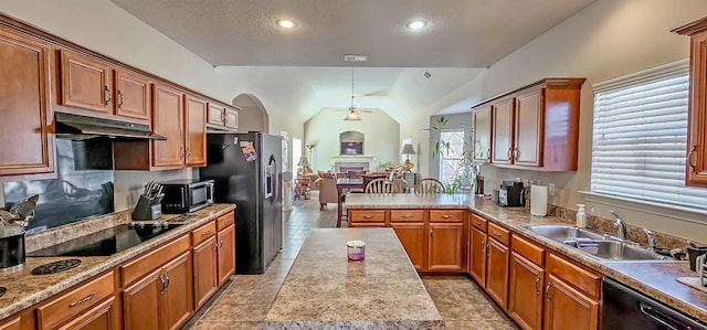 kitchen with lofted ceiling, under cabinet range hood, a sink, light countertops, and black appliances