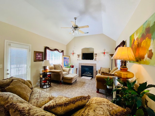 tiled living room with lofted ceiling, ceiling fan, and a tile fireplace