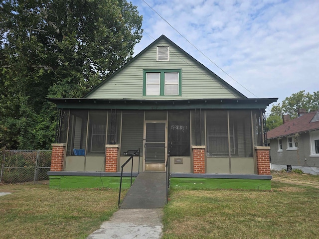 bungalow-style home featuring a front lawn and a sunroom