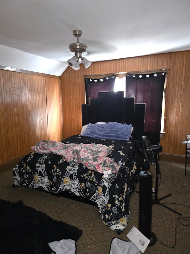 carpeted bedroom with wood walls and ceiling fan