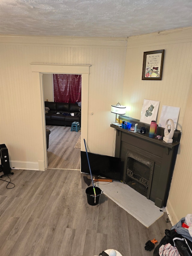 miscellaneous room with hardwood / wood-style flooring, wooden walls, and a textured ceiling