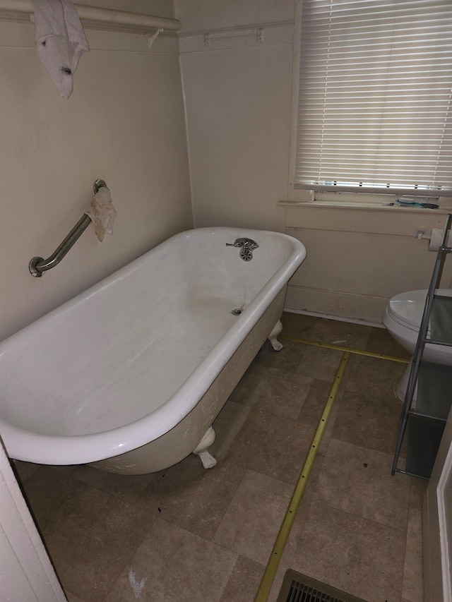 bathroom featuring a tub and toilet