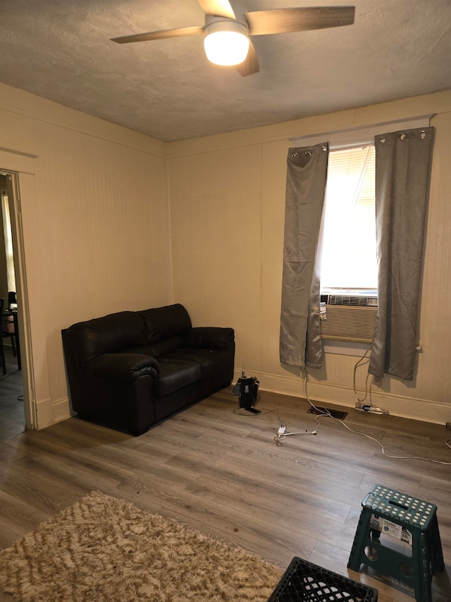 sitting room featuring dark wood-type flooring, a textured ceiling, cooling unit, and ceiling fan