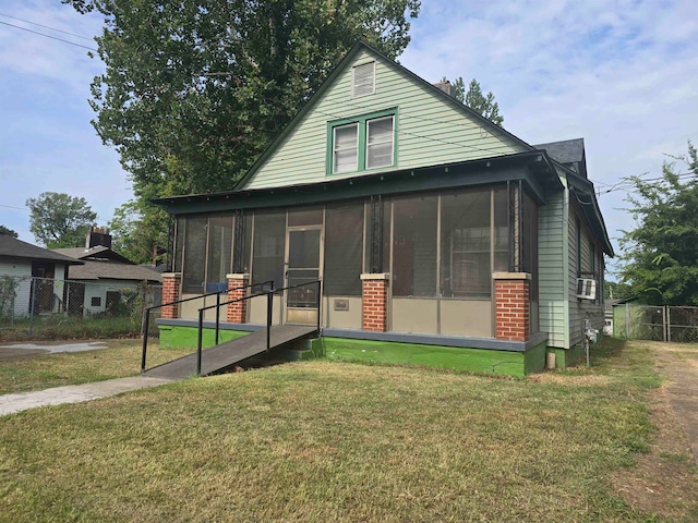 view of front of home with a sunroom and a front lawn