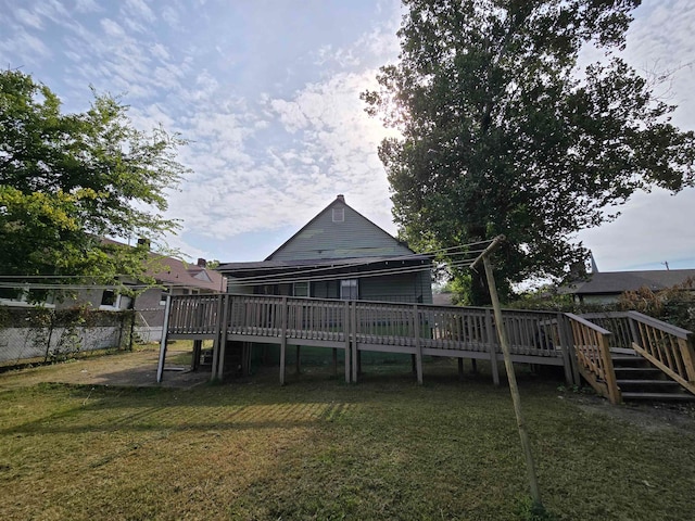 back of property with a wooden deck and a yard