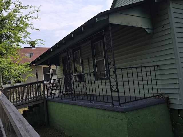 view of side of home featuring covered porch