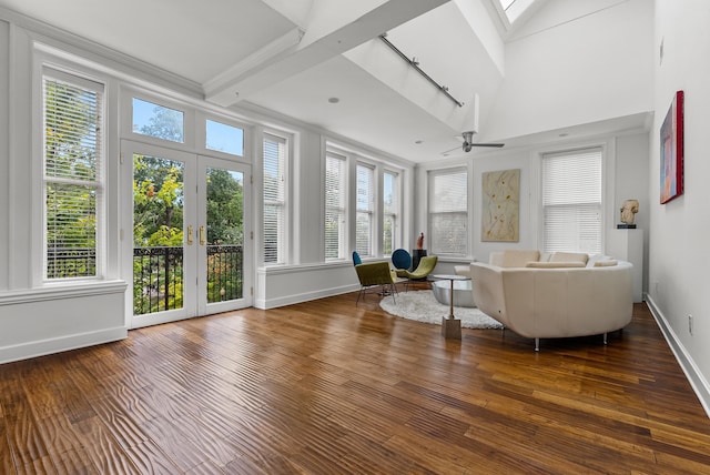 living room featuring baseboards, beam ceiling, french doors, a skylight, and wood-type flooring