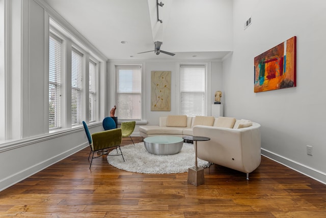 living room featuring baseboards, wood-type flooring, visible vents, and ceiling fan