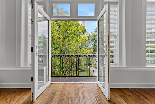 doorway to outside featuring french doors, baseboards, and wood finished floors