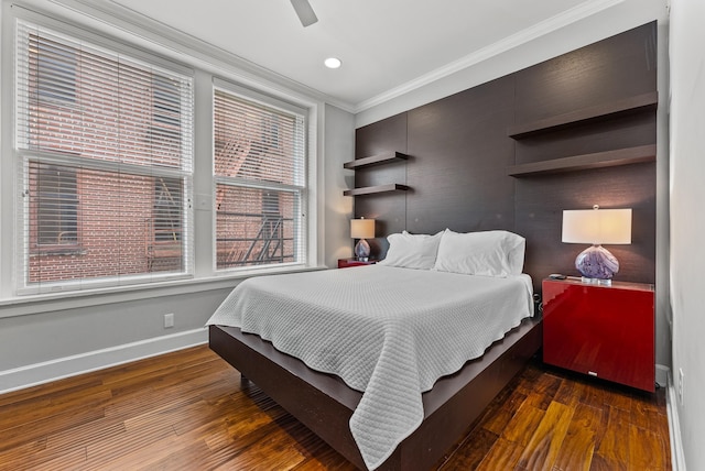 bedroom featuring ceiling fan, crown molding, baseboards, and wood finished floors