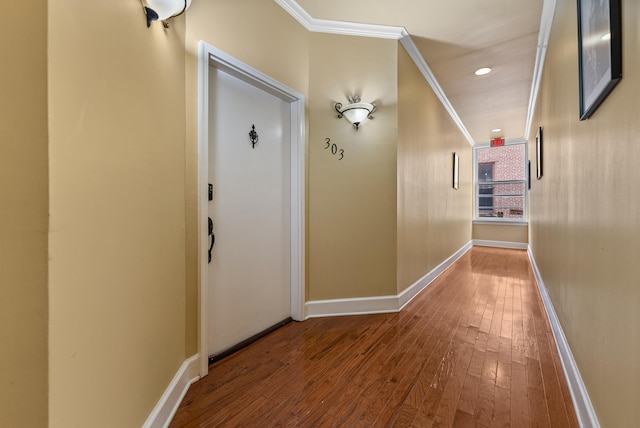 corridor featuring crown molding, hardwood / wood-style flooring, recessed lighting, and baseboards