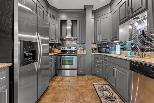 kitchen featuring a sink, stainless steel appliances, wall chimney exhaust hood, and gray cabinets