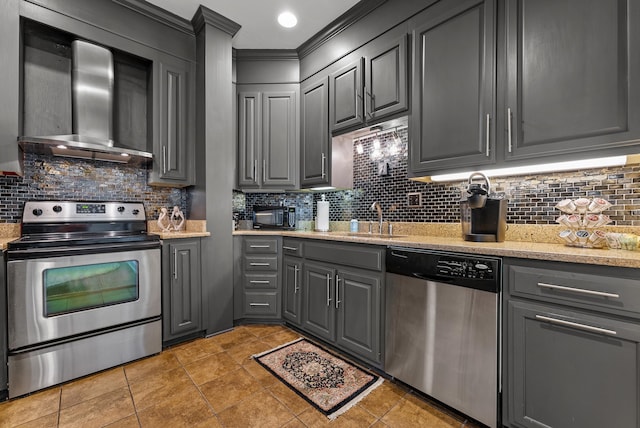 kitchen featuring tasteful backsplash, gray cabinets, appliances with stainless steel finishes, and wall chimney exhaust hood