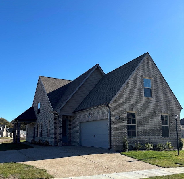 view of front facade with brick siding, an attached garage, and driveway